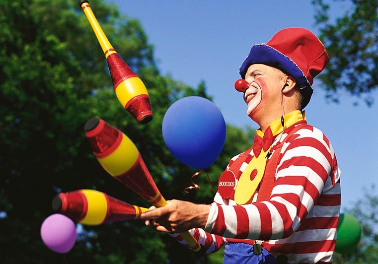 Clown with blue hair juggling colorful balls - wide 2